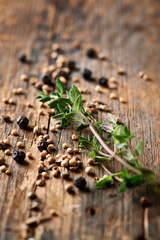 Assorted spices and thyme on wooden background