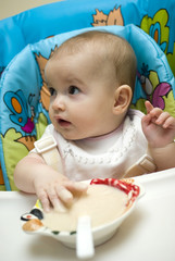 Caucasian baby girl feeding herself