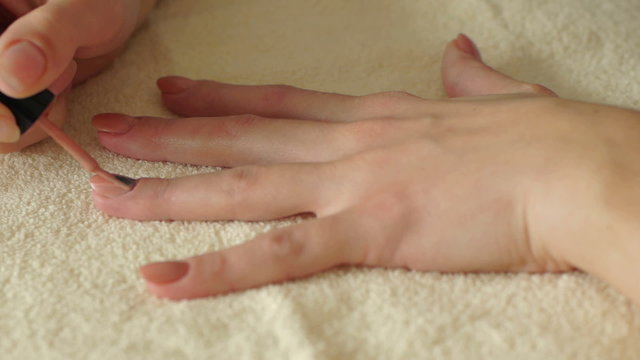 Woman makes manicure.