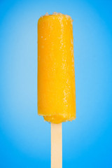 Yellow fruit juice ice on blue background