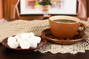 cup of coffee with scarf on table in room
