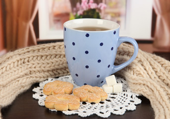 cup of tea with scarf on table in room