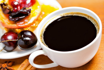 Cup of coffee and sweet fruit cake on a table