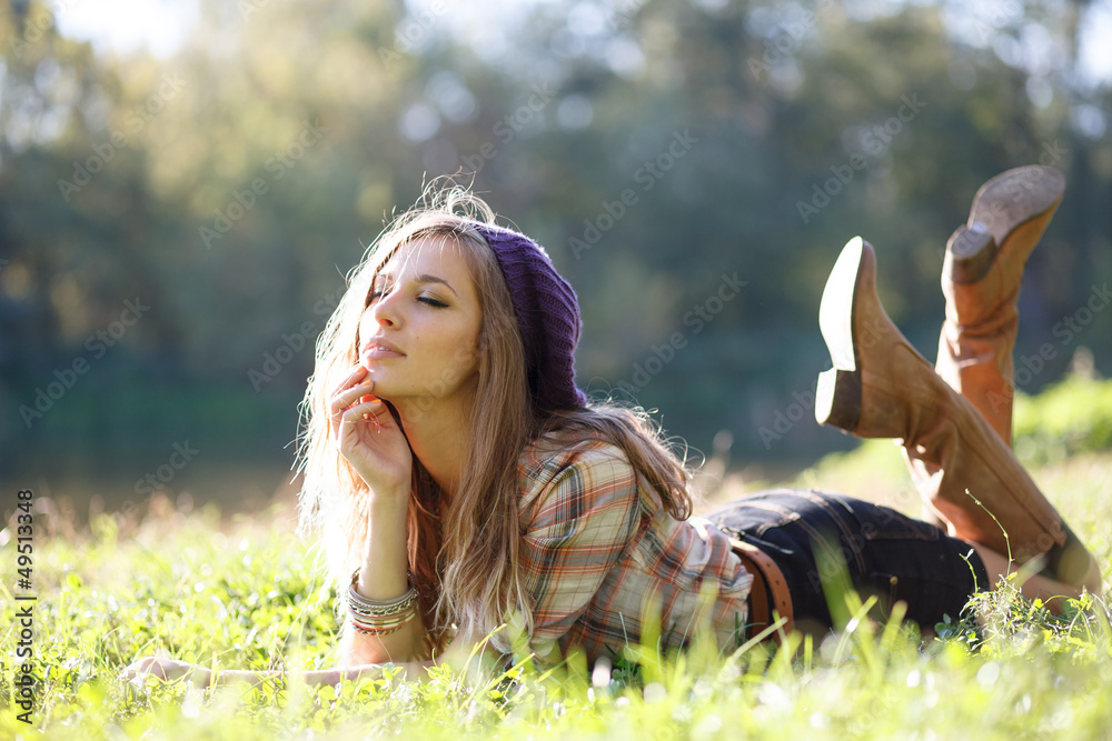 Wall mural beautiful young woman lying on grass with closed eyes