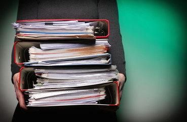 Female office worker carrying a stack of files