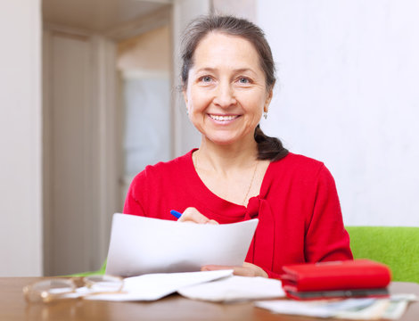 joyful  woman fills in payment documents