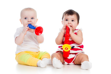 Funny babies girls  with musical toys. Isolated on white backgro