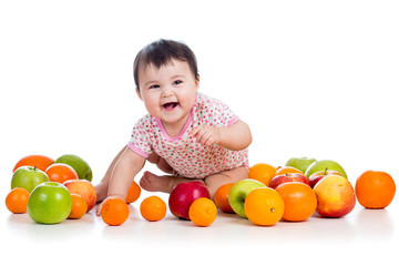 Fototapeta na wymiar happy girl dziecko siedzi wśród świeżych owoców