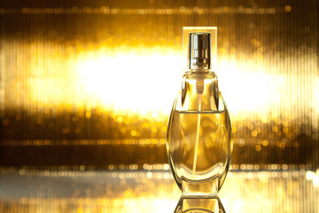 Bottle of perfume on gold background