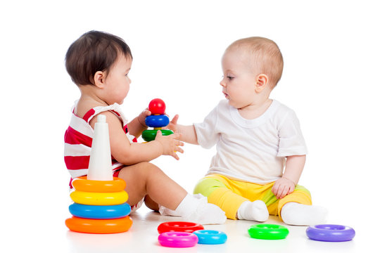 two babies girls playing together with color toys