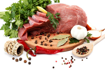 Raw meat, vegetables and spices on a wooden cutting board isolat