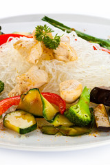 Roasted meat, rice noodles and vegetables on white background