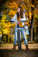 Fototapeta na wymiar Dziewczyna rowerowa w parku jesienią