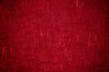 Grunge textured recycled red paper with natural fiber parts with