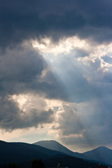 Sun rays through storm clouds - 49525774