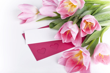 A bunch of pink tulips with a blank card for greetings