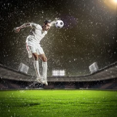 Abwaschbare Fototapete Fußballspieler, der den Ball schlägt © Sergey Nivens