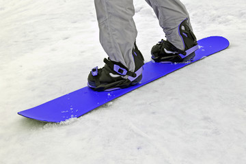 sportsman with blue snowboard on white snow, seasonal sport