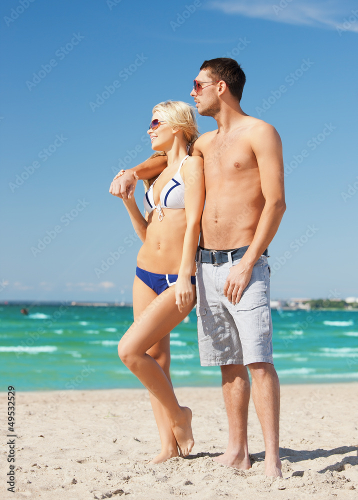 Poster happy couple in sunglasses on the beach