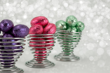 Foil easter eggs in wire eggcups.