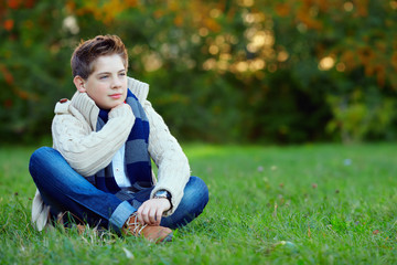 Fototapeta premium portrait of handsome teenager boy on green grass