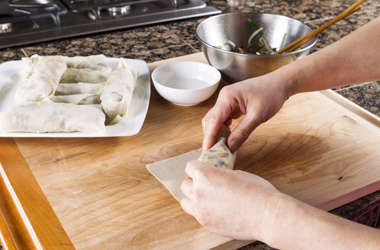 Creating homemade Chinese Spring Rolls in kitchen