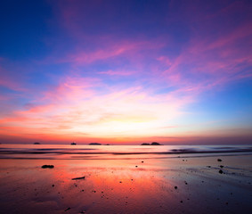 Sunset over ocean at low tide
