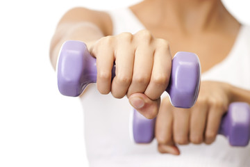 Close up of female hands holding dumbbells while working out