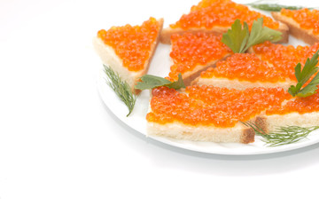 Red caviar on bread on white plate close-up