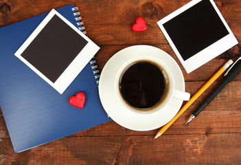 Cup of coffee on worktable covered with photo frames close up