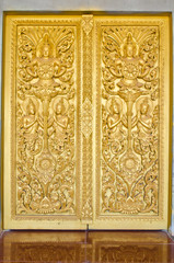 Fototapeta na wymiar Golden Thai design craft on wooden door in temple of Thailand