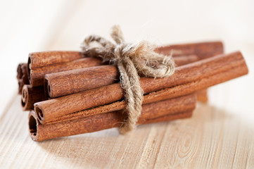 Bundle of cinnamon sticks on a wooden background, studio shot