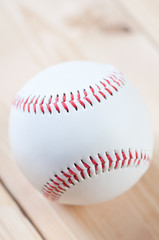 Vertical shot of a baseball ball on wooden boards