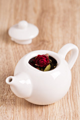 Green tea with fruits, spices, rose petals in white teapot