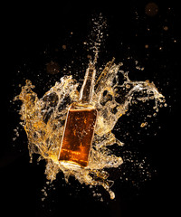 Concept of liquor splashing around bottle on black background - obrazy, fototapety, plakaty