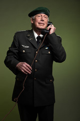 US military general wearing beret. Calling with phone. Studio po