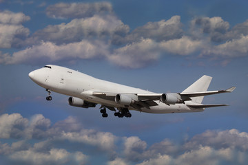 Naklejka na ściany i meble Biały samolot w błękitne niebo z chmurami