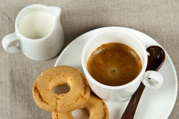 tazzina di caffè, biscotti e un bricchetto di latte