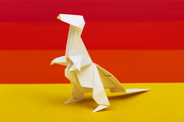 Origami white paper Tyrannosaurus Rex on colorful background.