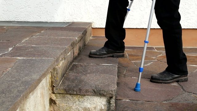 Person mit Kr&uuml;cken beim Treppensteigen
