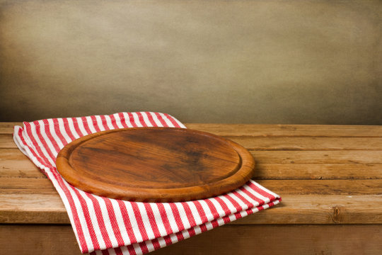 Wooden Board Stand On Tablecloth Over Grunge Background