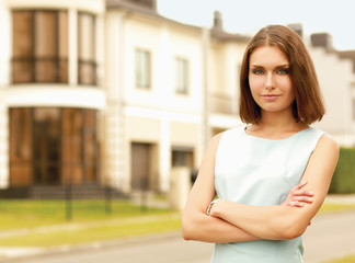 Young woman standing near house, isolated on white background