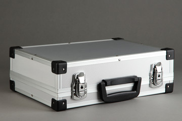 Silvery suitcase on grey background