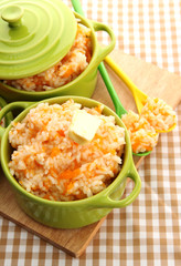 Taste rice porridge with pumpkin in saucepans