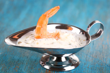 Shrimp in sauce tartare on blue wooden table close-up