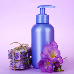 Obraz na płótnie Canvas Liquid and hand-made soaps on purple background