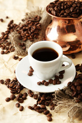 Cup and pot of coffee on beige background