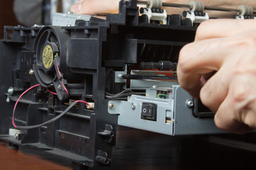 Fototapeta na wymiar men's hands repairing laser printer