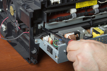 men's hands repairing laser printer