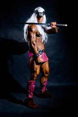 Naklejka premium Muscular man warrior with a sword on his shoulder